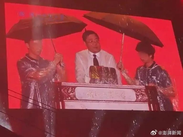 两名学生为冒雨演讲的校长撑伞，站在两把伞中间淋雨的校长，身上穿的衬衫都湿透了。（取材自澎湃新闻）