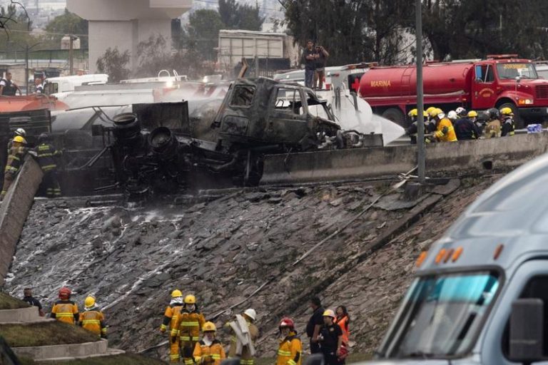 墨西哥市一辆瓦斯槽车翻覆爆炸，消防员为烧焦的拖车残骸降温。(路透)