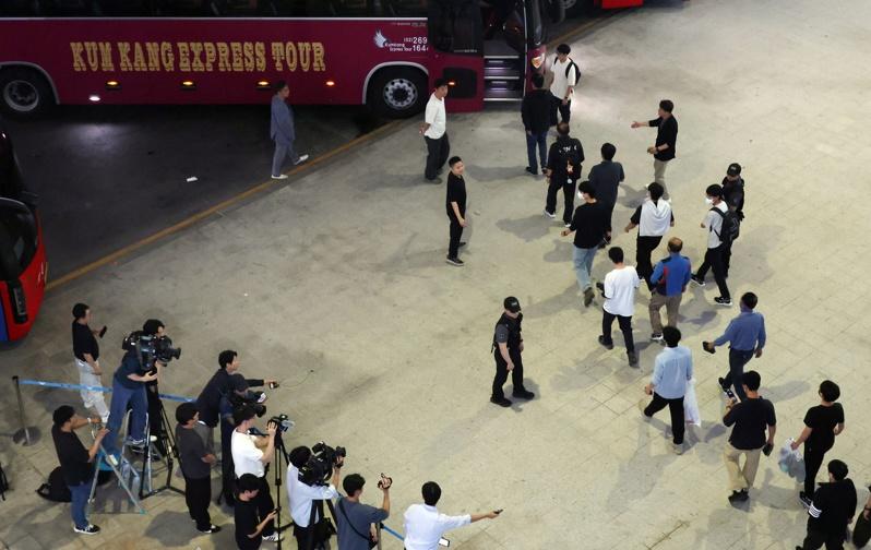 美国执法单位上周大举突袭现代汽车和LG在乔治亚州的电池工厂，当时被拘留的南韩工人12日返抵仁川国际机场之前，抗议民众举着美国总统川普身穿ICE制服的标语。（欧新社）