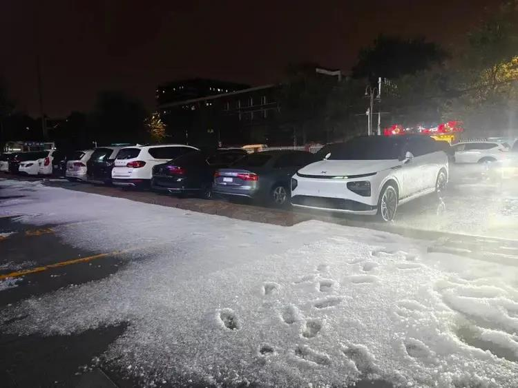 网友发布冰雹漂浮在路面雨水上，仿佛漂浮的冰河景象。（取材自北京交通广播）