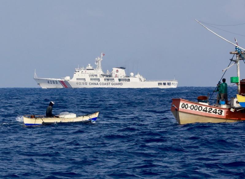 图为中国海警船2024年5月在南海黄岩岛海域巡逻,附近有些菲律宾渔船。(欧新社)