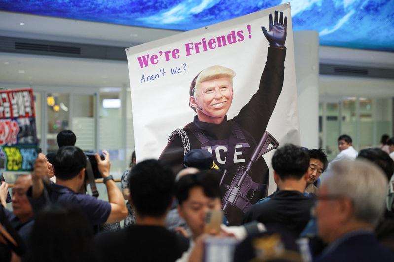 被美拘留的南韩工人12日返抵仁川国际机场,民众抗议美国移民突击检查。(路透)