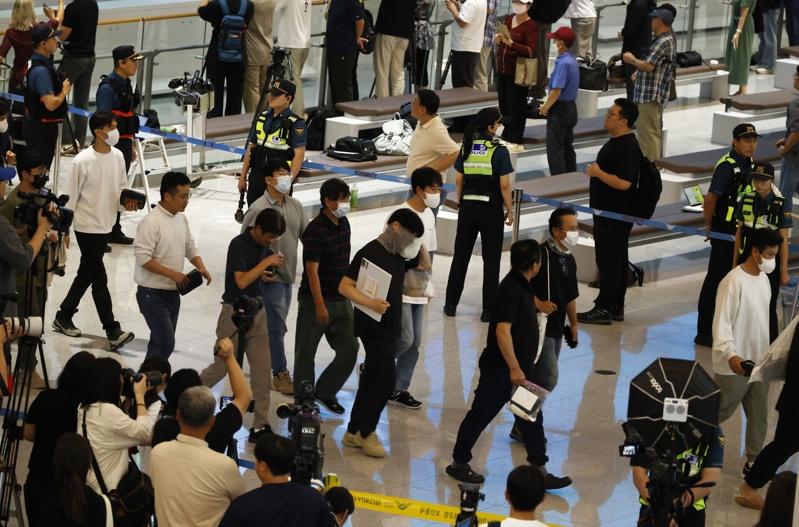 被美拘留的南韩工人12日返抵仁川国际机场，民众抗议美国移民突击检查。(路透)