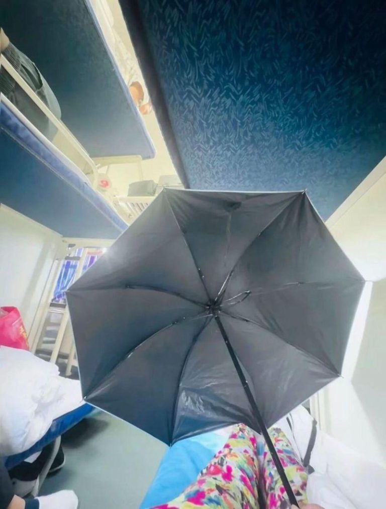 一名女生在火车卧舖打伞遮挡隐私引发热议。（视频截屏）