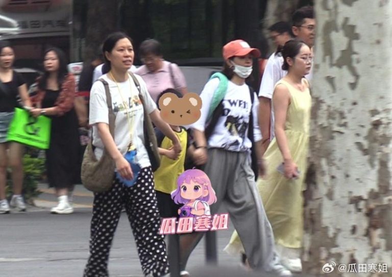 有媒体拍到赵丽颖（戴帽子和口罩者）和保母牵着儿子「想想」过马路。（取材自微博）