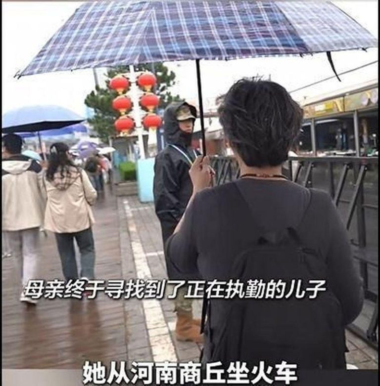 河南商丘的兵妈妈，撑着伞望着执勤中的儿子。（取材自大象新闻）