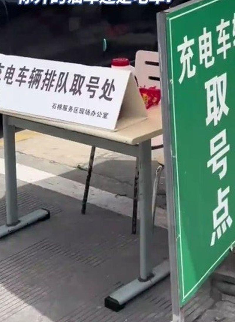 十一长假出游人数暴增,许多高速服务区的充电桩得排队叫号。(视频截屏)