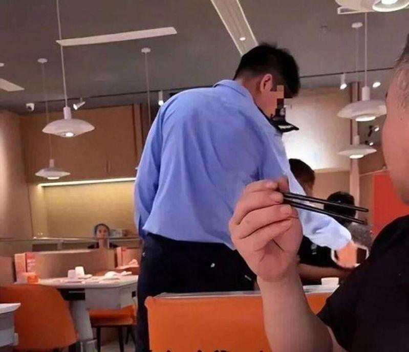办案民警直接在店里将小伙子上铐带走。（视频截屏）