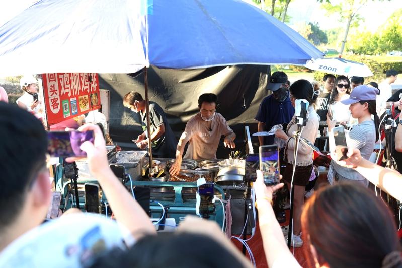 「鸡排哥」李俊永正在摊位前为顾客制作美食。(中新社)