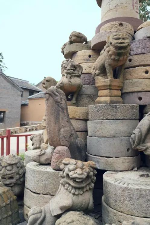 露天堆栈摆放的古建石构件及石狮。（取材自上游新闻）