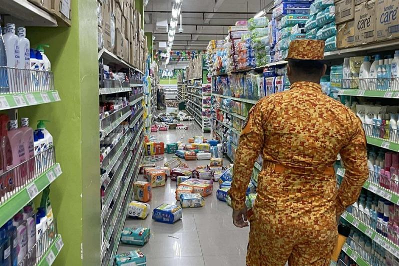 菲律宾南部外海10日上午发生规模7.4地震后,东纳卯省消防员和居民坚守倒塌建筑物。美联社