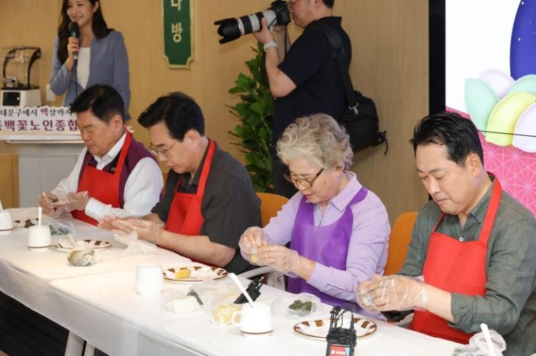 南韩在野党国民力量党党魁张东赫（右）2日参观首尔东大门一间养老机构时，和长者一起制作传统米制糕点松䭏。（欧新社）