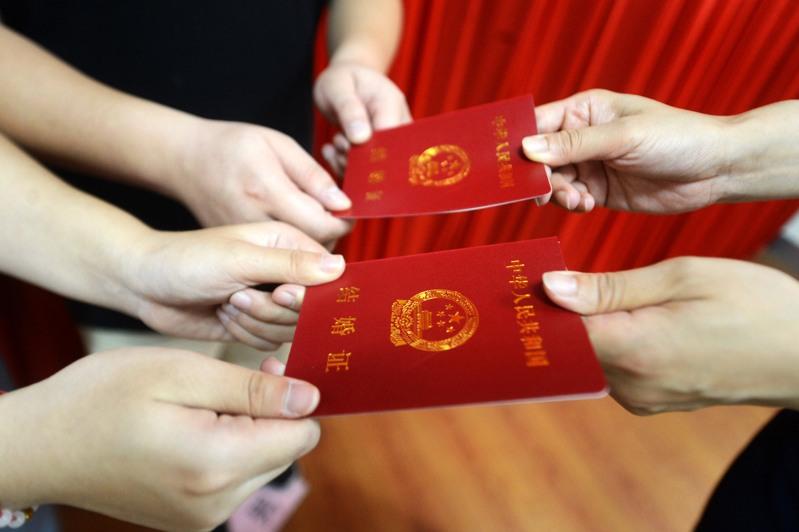 广东省自2026年1月1日起,夫妻任一方可凭有效证件依法查找对方名下的不动产与车辆登记信息,被外界形容为「打开婚姻黑箱」的重要一步。图为一对新人领取结婚证。(新华社)