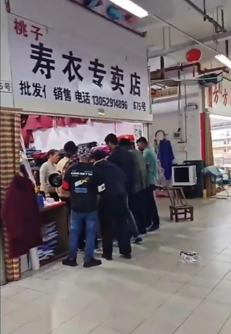 外国游客在江苏镇江某服饰店误将寿衣当作传统服饰购买。(视频截屏)