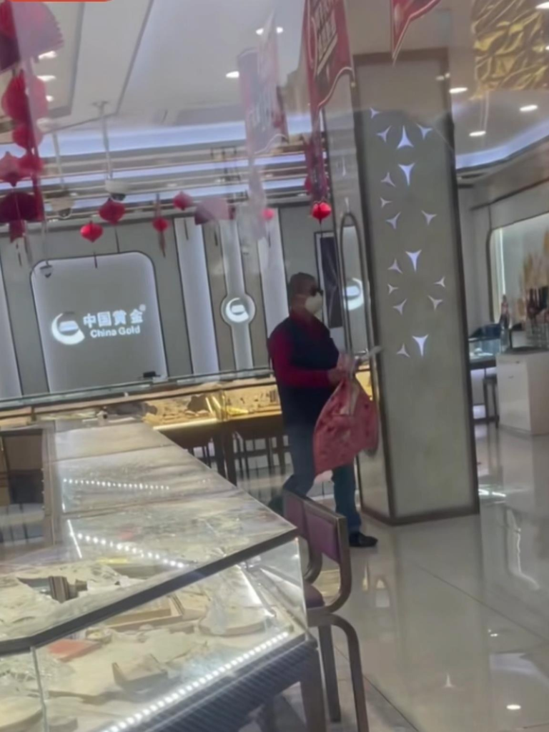 男子拿口袋抢劫上海一金店。（视频截屏）
