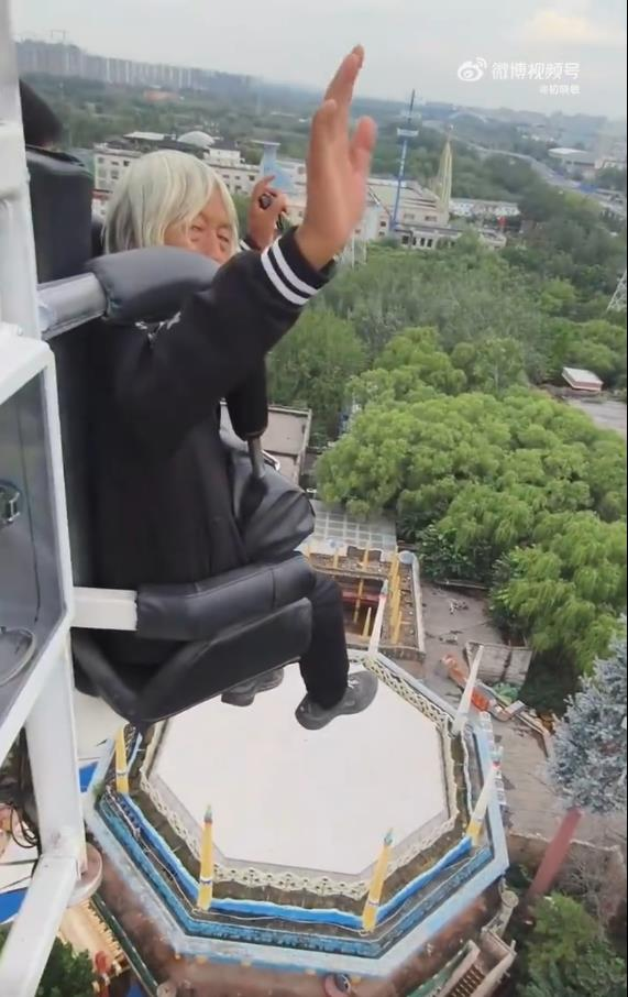 卢大爷坐过山车时不忘自拍。（视频截屏）