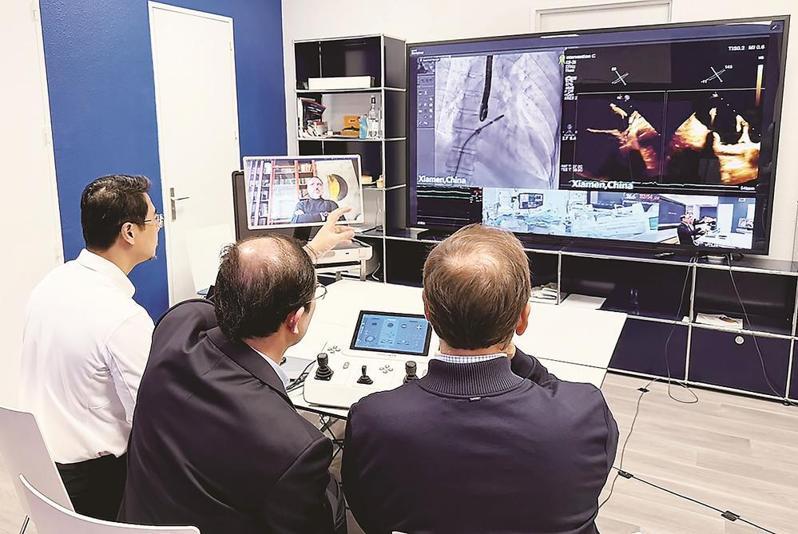 中国、法国团队远程协同操作，完成全球首例跨国机器人心脏介入手术。（取材自福建日报）