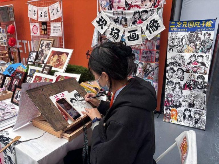 水墨手绘二次元国风画像 00后美术生毕业摆摊日入过千 00后摊主持毛笔为游客创作画像。(取材自九派新闻)