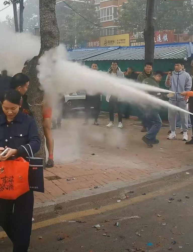 河南一名新郎被绑树上遭多人以灭火器喷射，现场画面被指荒唐。（取材自潇湘晨报）