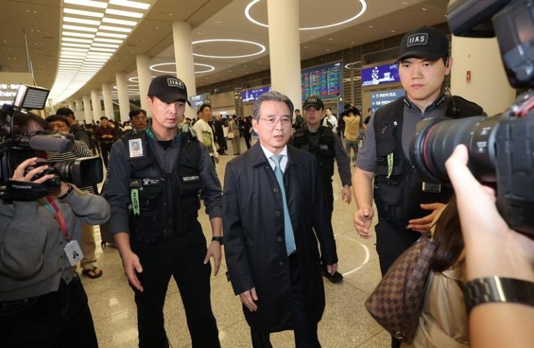 韩国总统办公室政策室长金容范(中)19日结束与美方官员进行关税谈判后，抵达韩国首尔仁川国际机场。欧新社