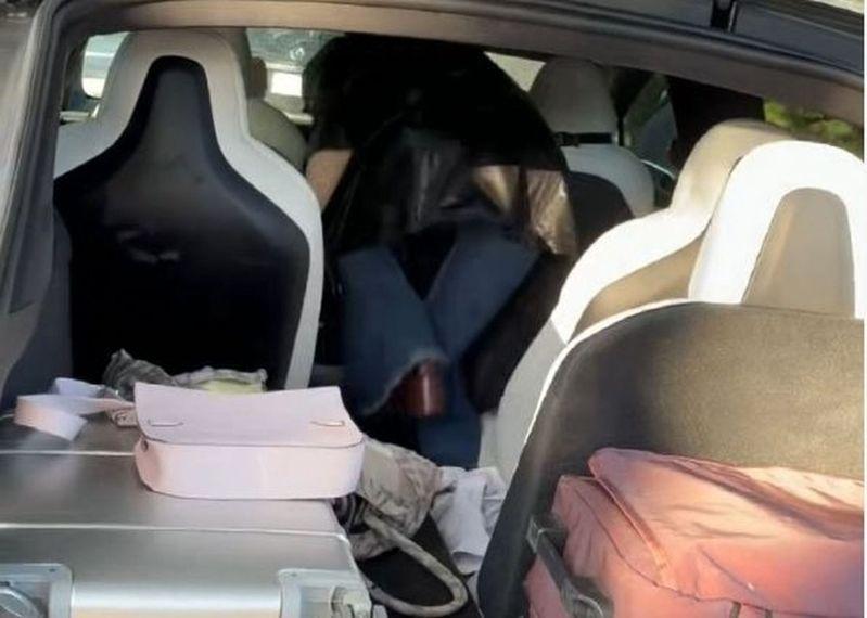 杨天真打不开特斯拉,只好爬后车厢进入。(取材自都市快报)