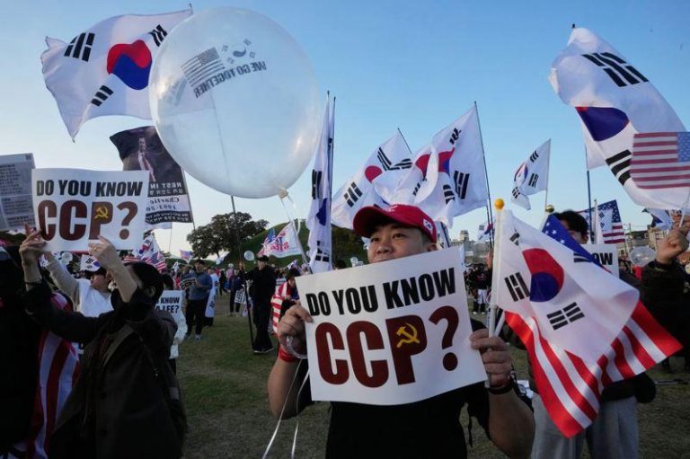 南韩庆州涌现大小示威活动，美国总统川普的支持者29日在庆州举着反对中共的标语集会，欢迎川普到访。（美联社）