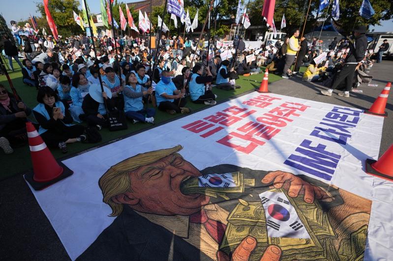 南韩庆州涌现大小示威活动，美国总统川普的支持者29日在庆州举着反对中共的标语集会，欢迎川普到访。（美联社）