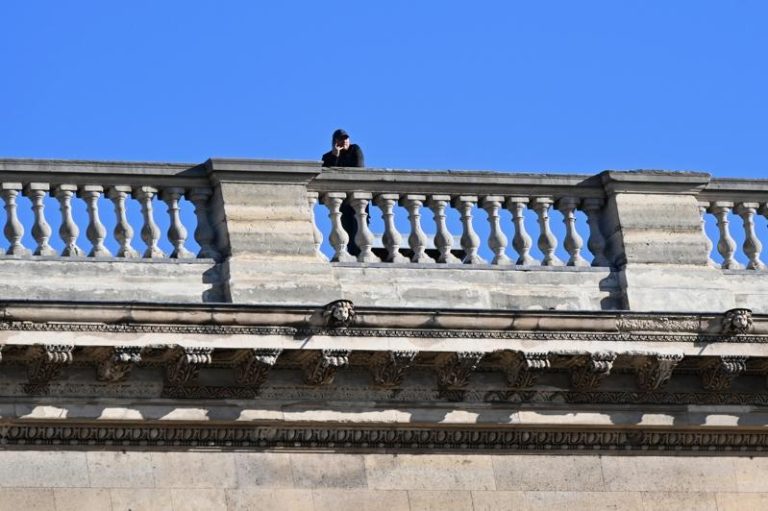 图为一名人士站在罗浮宫阳台上。(美联社)