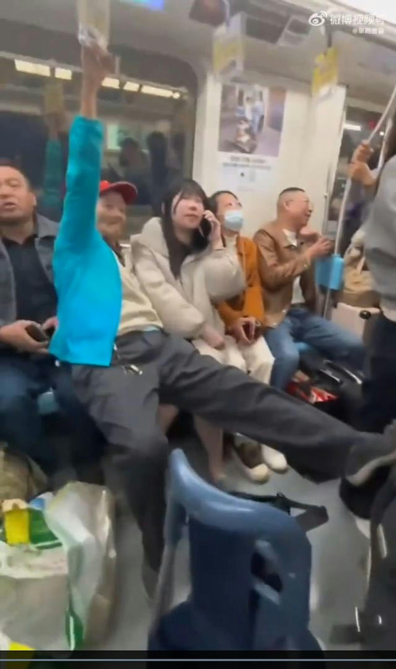 老人直接坐在了女乘客和旁边乘客的腿上，一手抓着吊杆，另一只手疑似向女乘客方向伸了过去。（视频截屏）