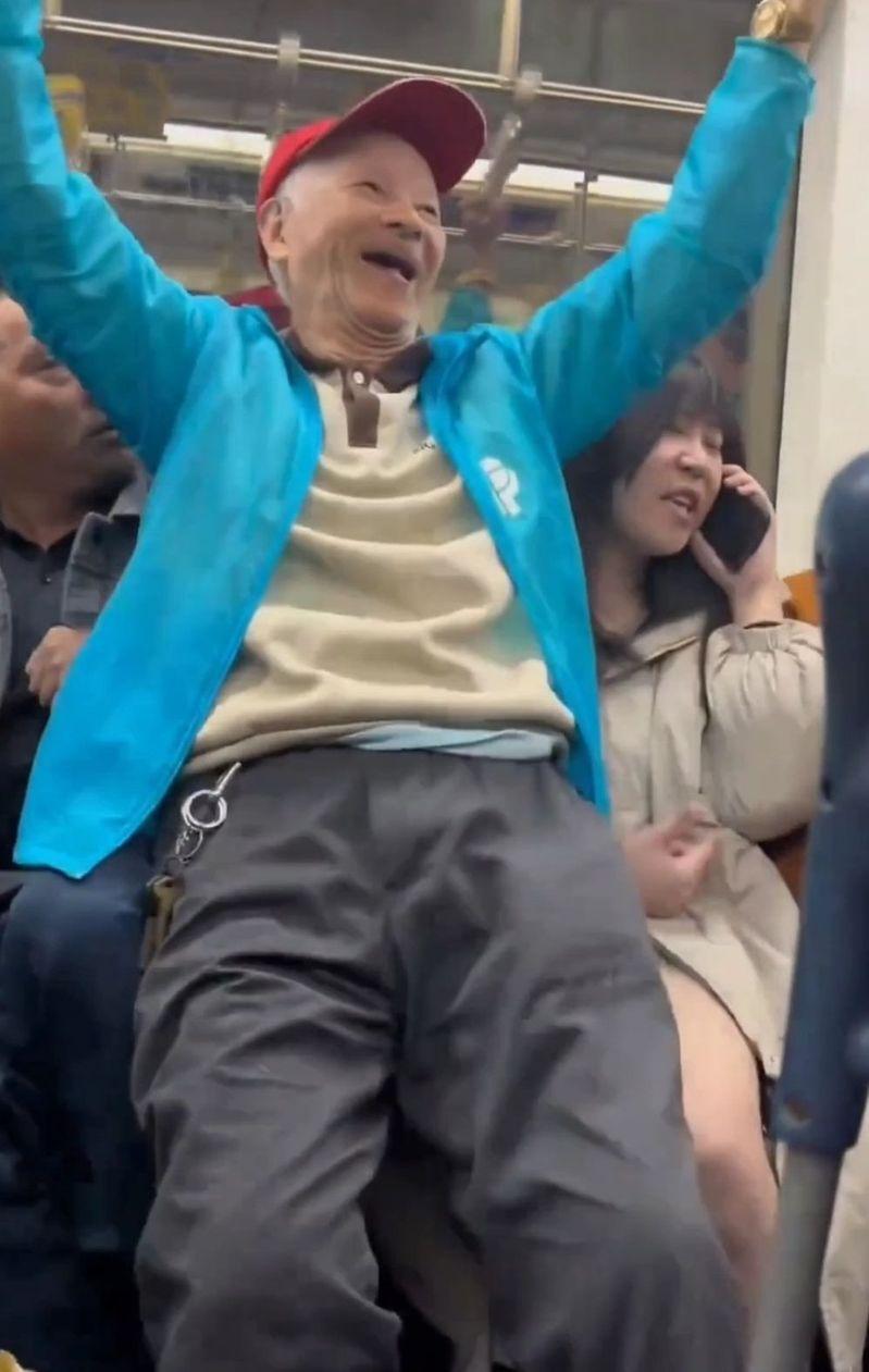 老人直接坐在了女乘客和旁边乘客的腿上，一手抓着吊杆，另一只手疑似向女乘客方向伸了过去。（视频截屏）