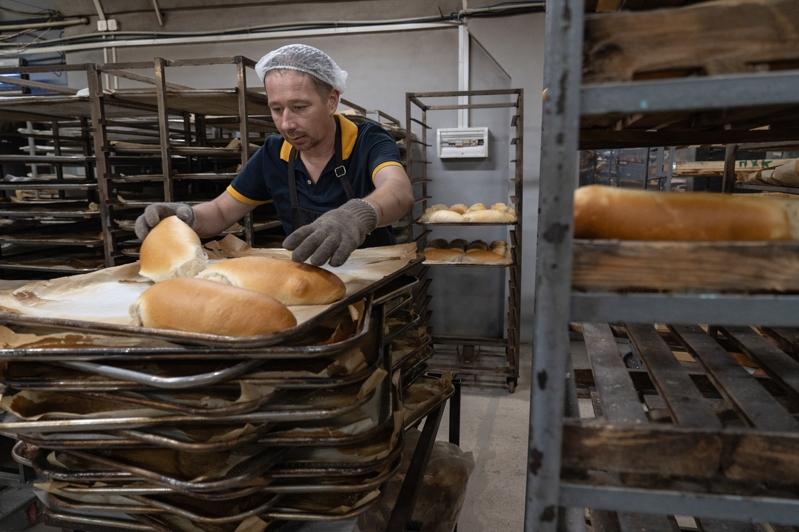 乌克兰男子奥列赫开设烘培工场为前线居民送赠面包。这间位处斯拉维扬斯克的烘培工场,已是奥列赫因战火被迫迁的第三个据点。(中央社)