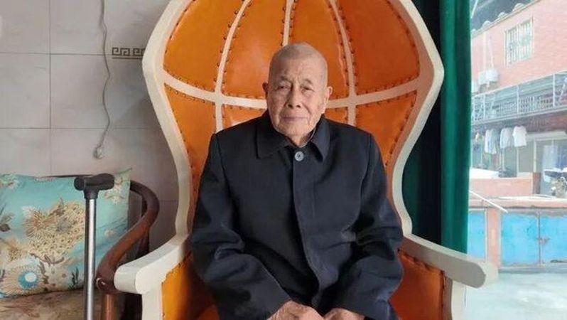 马德本坐在一楼入户的沙发凳上。(取材自橙柿交互·都市快报)