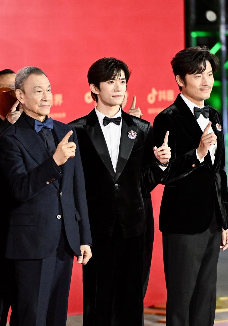第38届中国电影金鸡奖红毯仪式15日在福建厦门举行。图为演员易洋千玺(中)、王学圻(左)、耿乐在红毯亮相。(中新社)