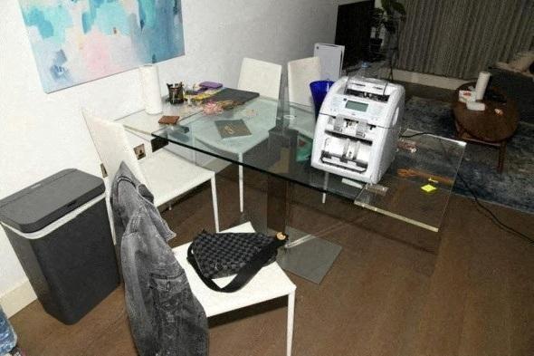 英国国家打击犯罪局在「扰乱行动」中所查获的现金和一台点钞机。(路透)