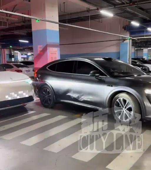 银灰色智界R7在倒车进车格时「挤」到了白色问界M8。(取材自都市现场)