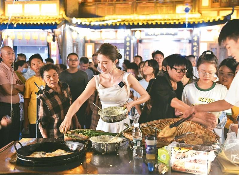 重庆发展夜间经济,60%以上的消费发生在夜晚。图为重庆荣昌市民逛夜市品尝美食。(中新社)