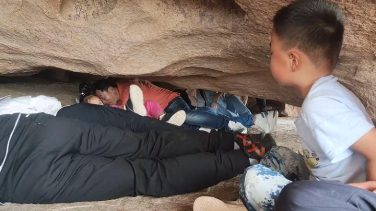 游客穿过「滚龙洞」。（视频截屏）