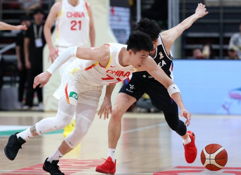 中国队球员张镇麟(左)28日在比赛中拚抢。(新华社)
