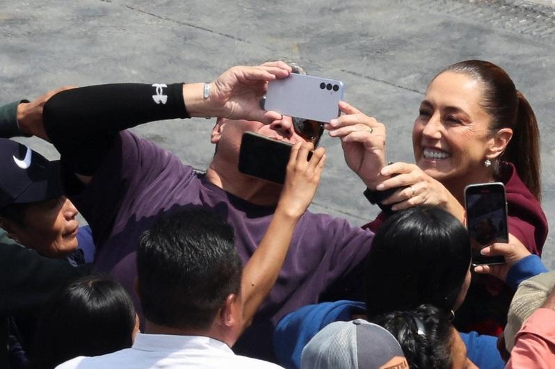 薛恩鲍姆作风亲民，常和民众合影聊天。图为10月5日她发表就职一周年演说，并和民众拍照。路透