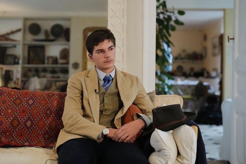 15岁少年佩德罗8日在巴黎南部蓝布耶的家中,与自己在罗浮宫劫案发生当天被美联社拍摄到的照片合影。(美联社)