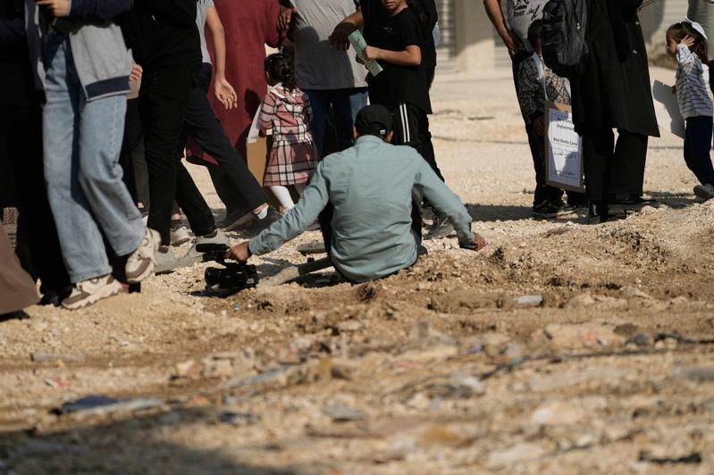 一名半岛电视台摄影记者雅新(中)在报导以色列军人驱散巴勒斯坦抗议人士时，腿部中弹受伤，之后由救护车送医治疗。(美联社)