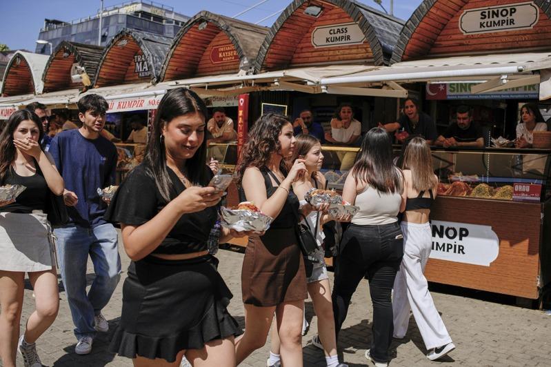 人们在伊斯坦堡的奥塔科伊（Ortakoy）海滨广场品尝街头美食。美联社