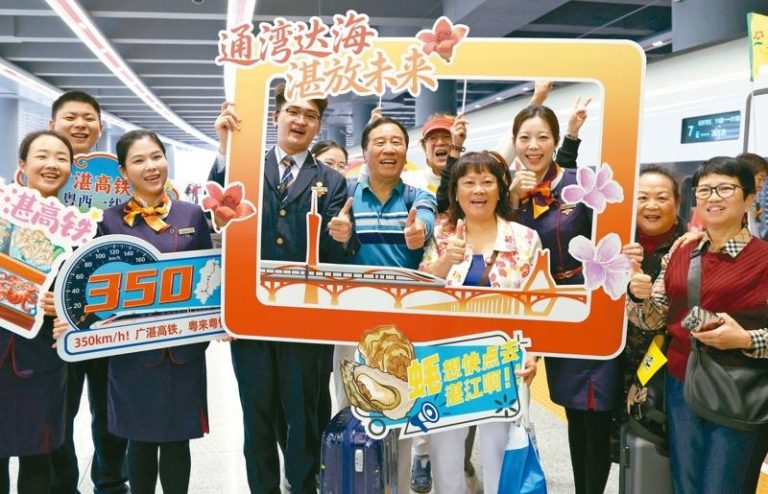广州至湛江高铁22日通车，首发列车的旅客与工作人员在广州白云站合影。（新华社）