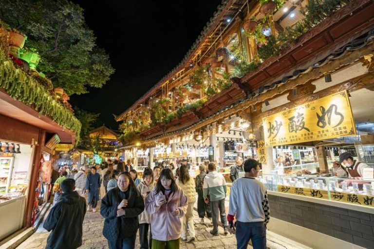 游客在丽江古城内游玩。（新华社）