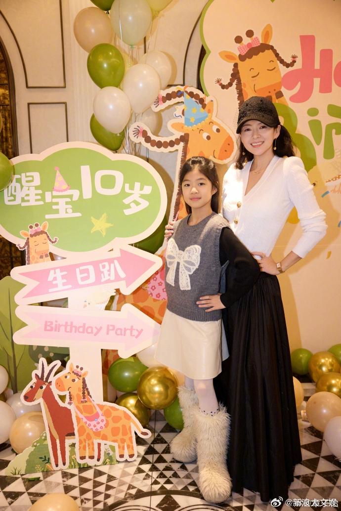 章子怡为女儿醒醒庆生,醒醒手上拿的是她出版的绘本「想变矮的长颈鹿」。(取材自微博)」