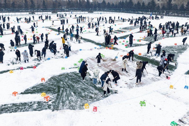 哈工程千余师生在军工操场上绘就雪地航母。(新华社)