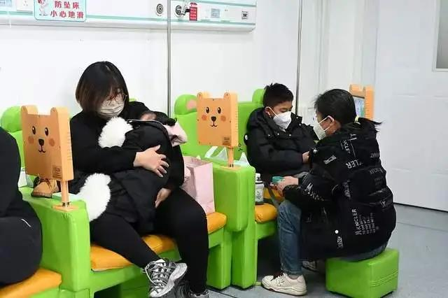2025年12月1日,内蒙古医科大学附属医院儿科,家长陪儿童诊疗流感。(中新社)