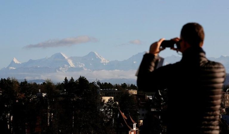 根据瑞士雪崩研究所（SLF）数据，高海拔山区的伯恩高地今年降雪约为往年一半或1/3。图为2019年12月10日，一名男子在瑞士拍摄伯恩高地的风景。(路透)