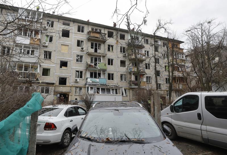 俄罗斯今天发动大规模攻击，造成全境至少3人丧生。图为俄罗斯无人机空袭中击中乌克兰基辅一栋公寓大楼，一名受伤老妇人从破碎窗户无助望向远方。(美联社)