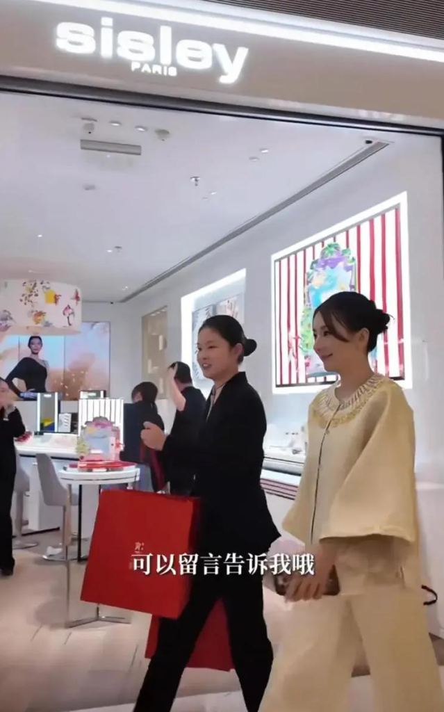 方媛贵气现身上海 刷卡买金饰像买菜 送方媛(右)由店员提着两大袋战利品送到门口。(视频截屏)